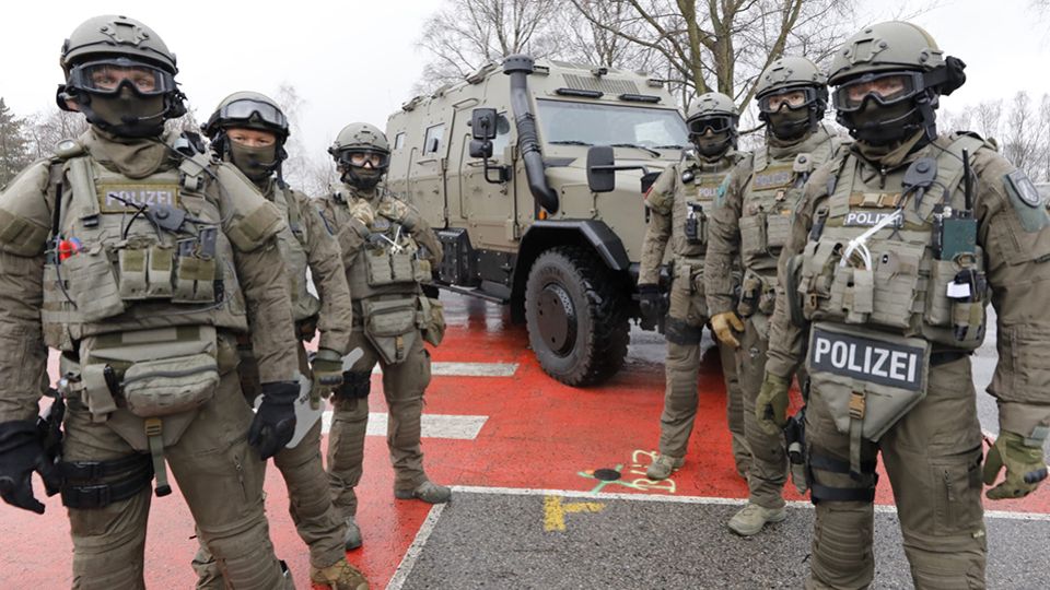 Spezialeinsatzkommando vor dem Anti-Terror-Fahrzeug 'Survivor R' 